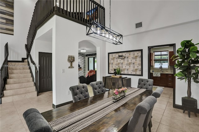 dining area with light tile patterned floors and a high ceiling