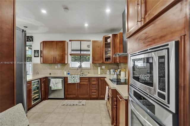 kitchen featuring sink, wine cooler, light tile patterned floors, tasteful backsplash, and stainless steel appliances