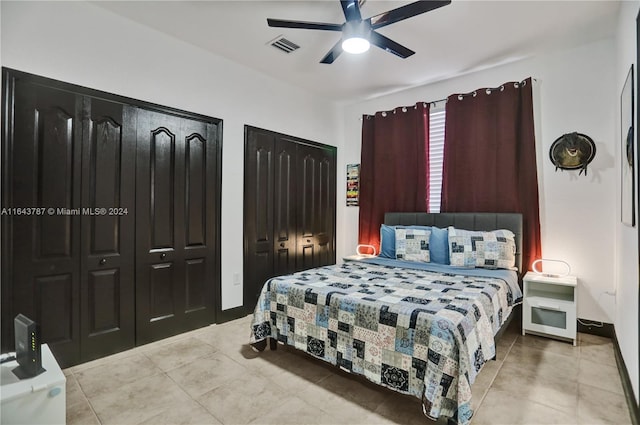 bedroom with ceiling fan and multiple closets