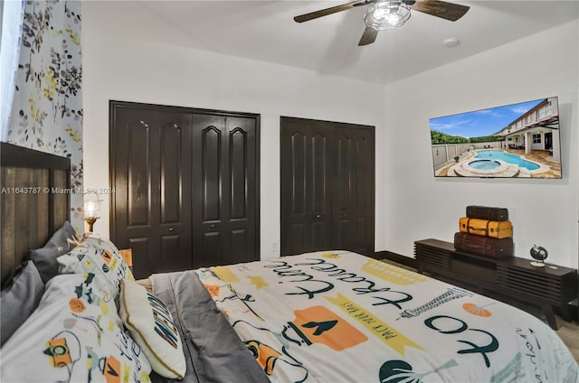 bedroom with ceiling fan and two closets