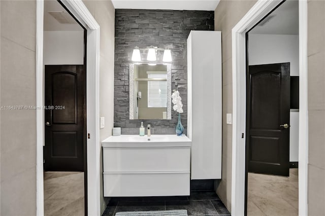 bathroom with tile patterned flooring, vanity, and tile walls