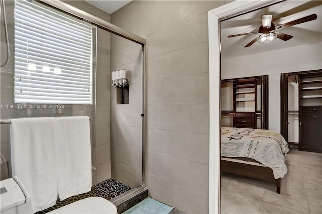 bathroom with ceiling fan, toilet, and a shower with shower door