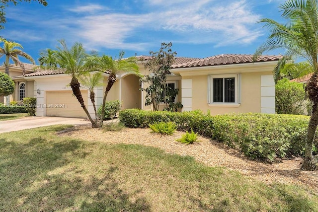 mediterranean / spanish home featuring a garage and a front yard