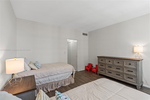 bedroom with dark hardwood / wood-style floors and a closet