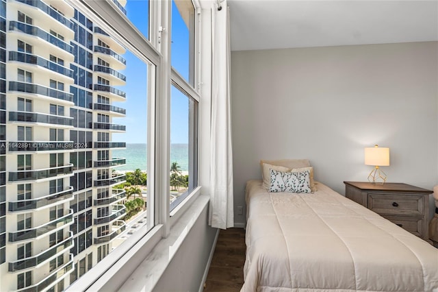 bedroom with a water view and hardwood / wood-style flooring