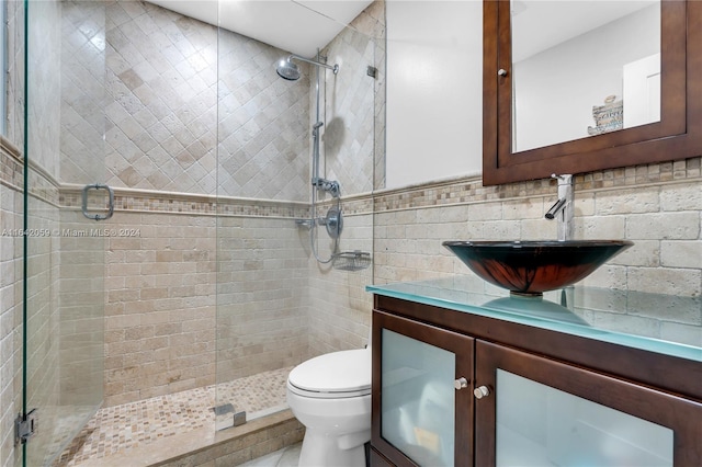 bathroom featuring an enclosed shower, tasteful backsplash, vanity, tile walls, and toilet