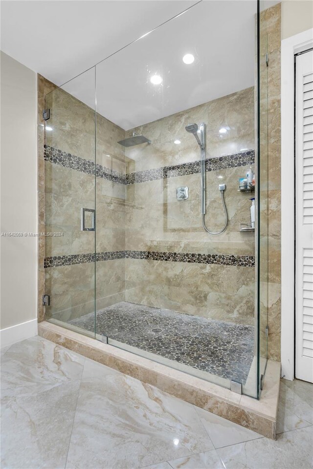 bathroom with tile patterned flooring and a shower with shower door