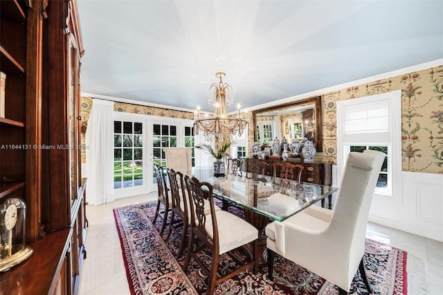 dining area featuring ornamental molding, wainscoting, an inviting chandelier, and wallpapered walls