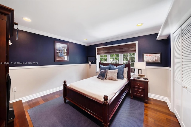 bedroom featuring ornamental molding, a closet, dark wood finished floors, and baseboards