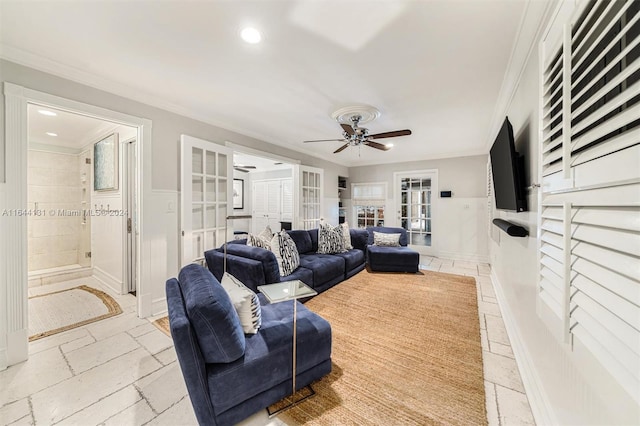 living area featuring french doors, crown molding, and stone tile floors