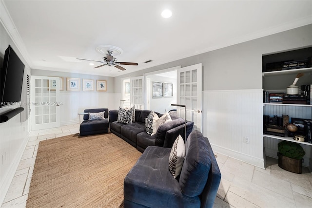 living area with recessed lighting, a wainscoted wall, a ceiling fan, stone tile flooring, and crown molding