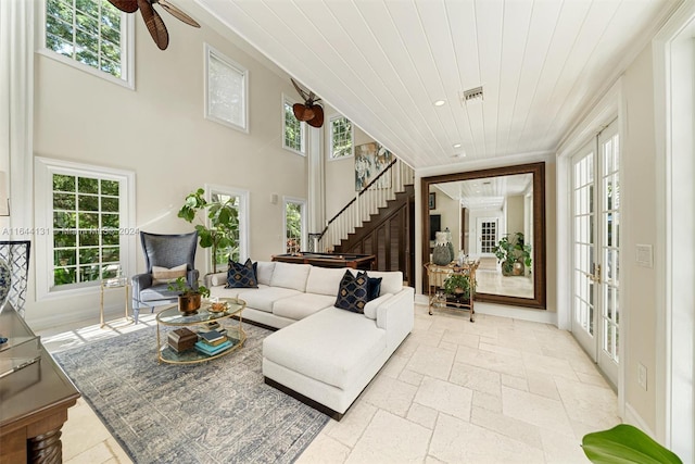 living area featuring a wealth of natural light, wood ceiling, stone tile flooring, and stairs