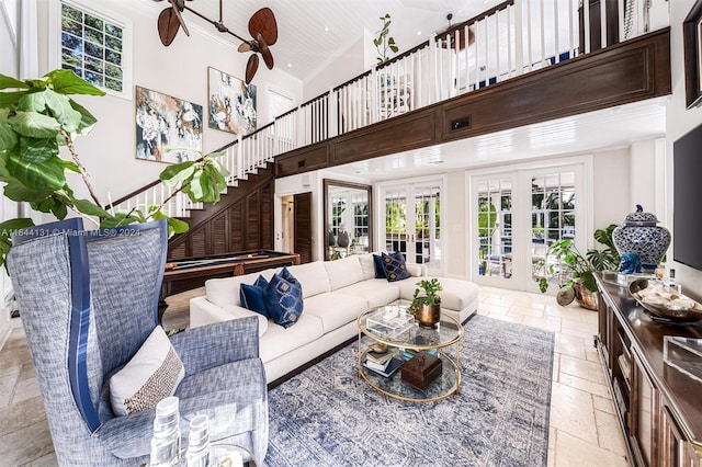 living room with high vaulted ceiling, stone tile floors, a ceiling fan, stairs, and french doors