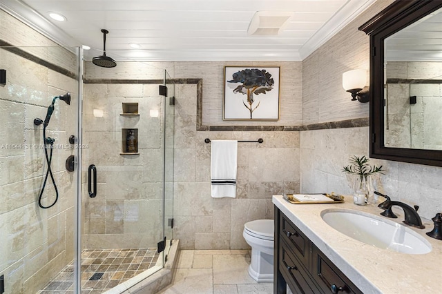 bathroom featuring a stall shower, toilet, ornamental molding, vanity, and tile walls