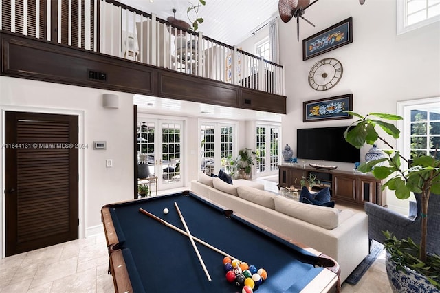 rec room featuring a wealth of natural light, french doors, and a towering ceiling