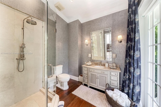 full bath featuring toilet, vanity, a shower stall, wood finished floors, and wallpapered walls