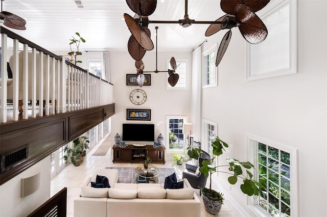 living room with wooden ceiling, ceiling fan, a high ceiling, and stairs