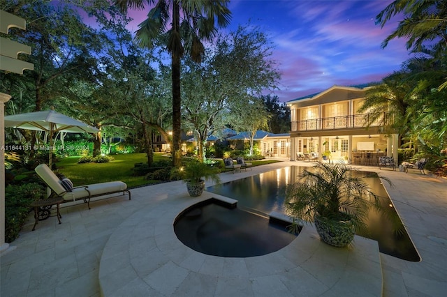 exterior space featuring a patio area, a yard, a hot tub, and a swimming pool