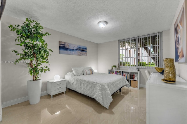 bedroom with a textured ceiling and light tile patterned floors