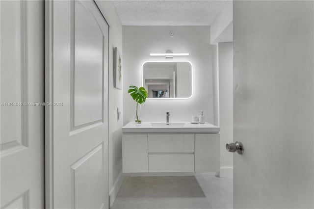 bathroom with a textured ceiling and vanity