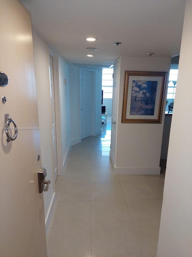 hall featuring plenty of natural light and light tile patterned flooring