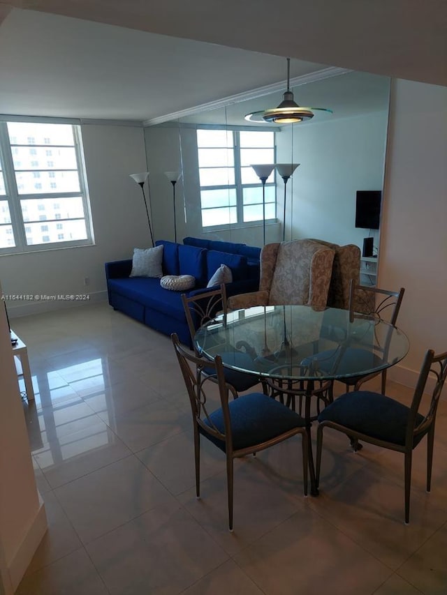 dining room featuring crown molding and light tile patterned floors