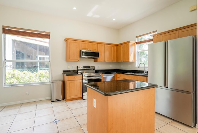 kitchen with appliances with stainless steel finishes, a center island, light tile patterned flooring, and sink