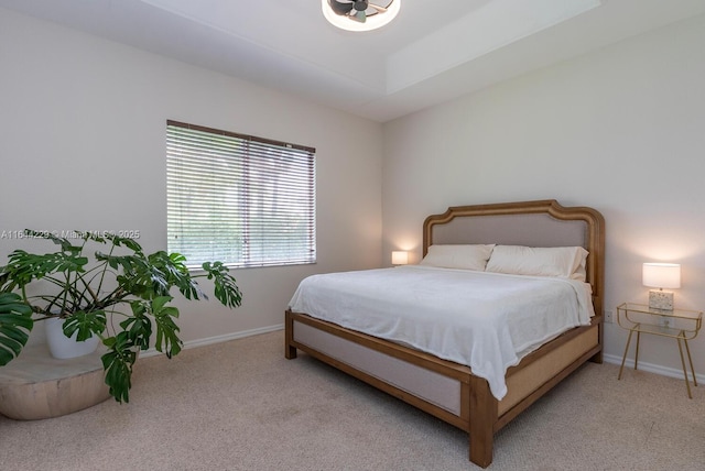 bedroom featuring light carpet and baseboards