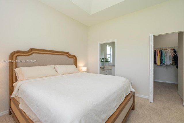 bedroom featuring baseboards, a spacious closet, a closet, and light colored carpet