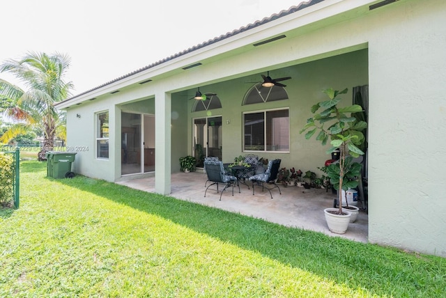 back of house featuring ceiling fan, a patio area, and a lawn