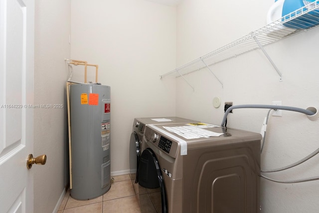 laundry room with light tile patterned floors, electric water heater, laundry area, separate washer and dryer, and baseboards