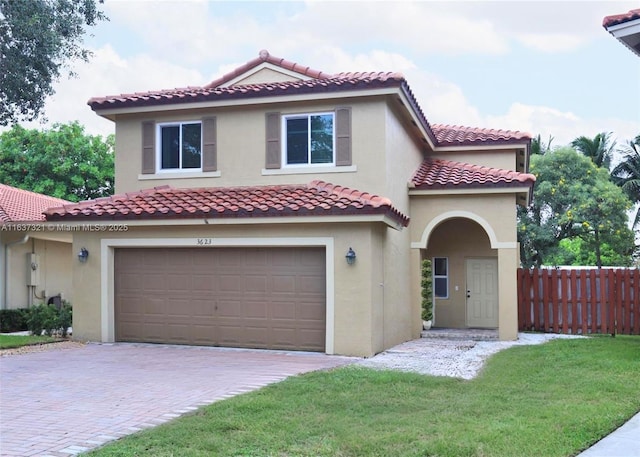 mediterranean / spanish house featuring a garage and a front lawn