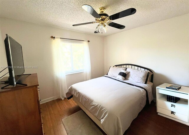 bedroom with wood-type flooring, a textured ceiling, and ceiling fan