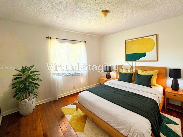 bedroom featuring dark hardwood / wood-style flooring and a textured ceiling