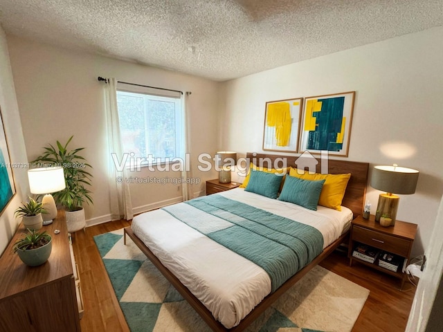 bedroom with dark wood-type flooring and a textured ceiling