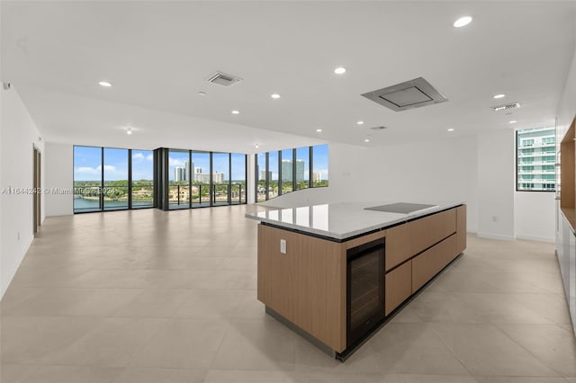 kitchen featuring plenty of natural light, a wall of windows, wine cooler, and a kitchen island