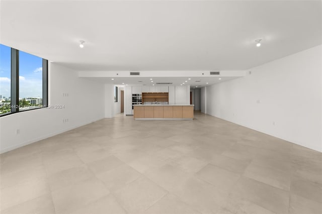 unfurnished living room featuring expansive windows and light tile patterned flooring