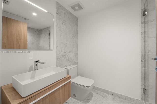 bathroom featuring tile patterned flooring, a tile shower, vanity, and toilet