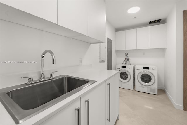 washroom with sink, light tile patterned floors, separate washer and dryer, and cabinets