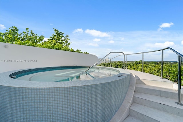 view of swimming pool featuring an in ground hot tub