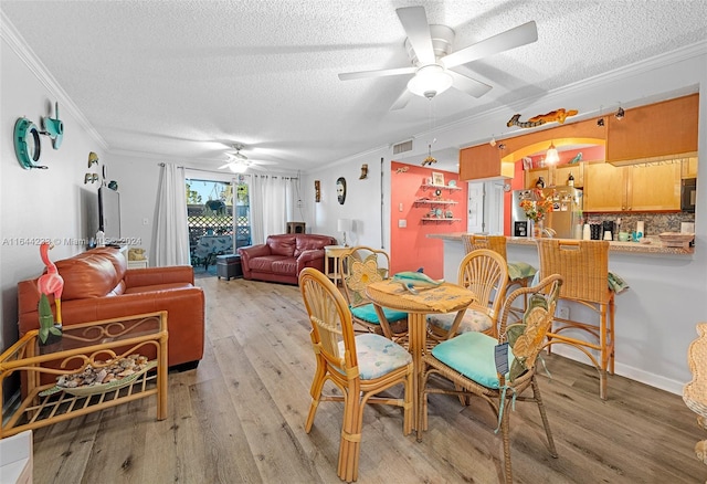 dining area featuring a textured ceiling, light hardwood / wood-style flooring, ceiling fan, and ornamental molding