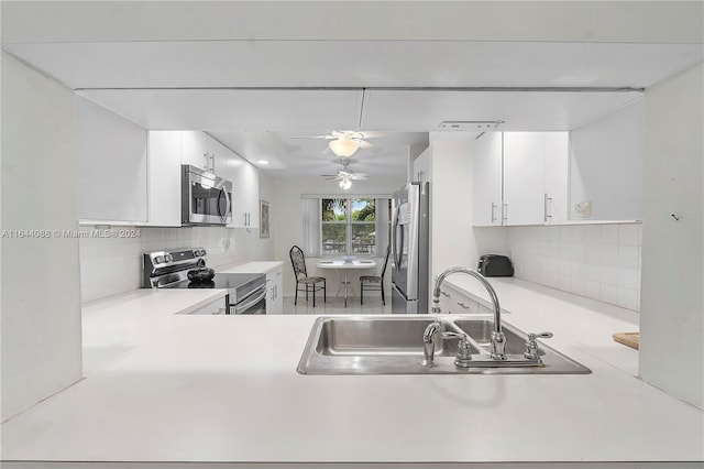 kitchen with ceiling fan, white cabinets, backsplash, and stainless steel appliances