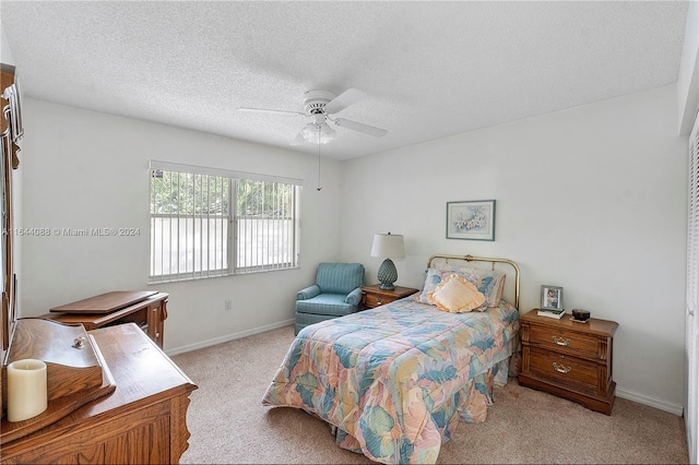 carpeted bedroom with a textured ceiling and ceiling fan