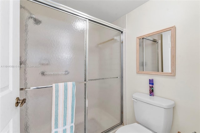 bathroom with an enclosed shower and toilet