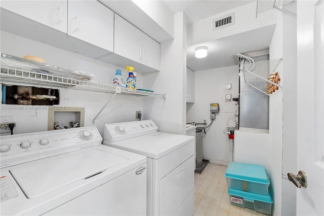 washroom featuring light tile patterned floors, independent washer and dryer, a textured ceiling, and cabinets