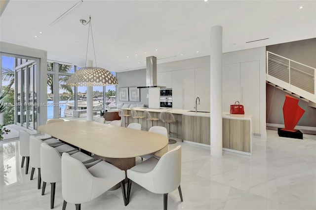 tiled dining room featuring sink and floor to ceiling windows