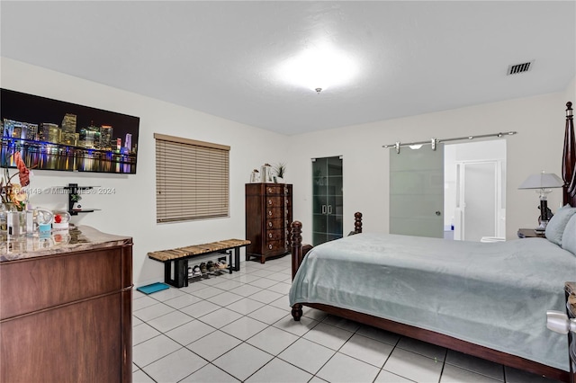 bedroom with light tile patterned flooring and a barn door