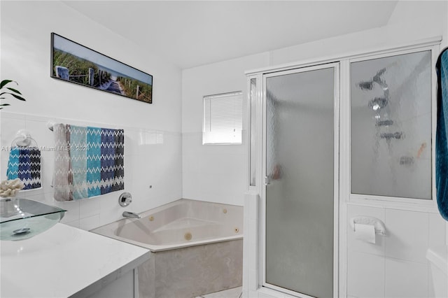 bathroom featuring tile walls, separate shower and tub, and vanity