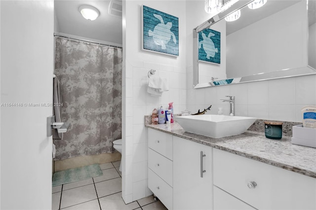 bathroom featuring tile patterned flooring, tile walls, vanity, and tasteful backsplash