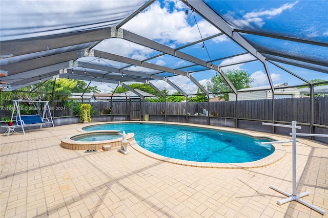 view of pool featuring a patio area, an in ground hot tub, and a lanai